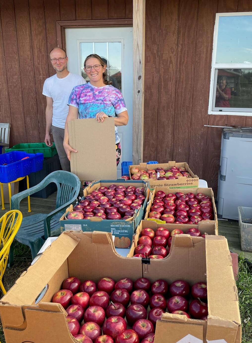 Giving Tree Farm owners with boxes of apples